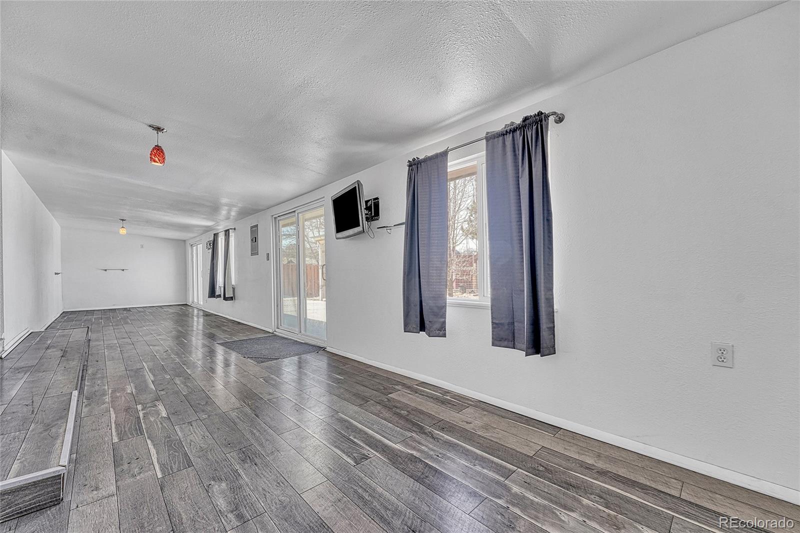 7461 Webster Street Arvada, CO 80003 - Photo 10 of 31 a view of an empty room with wooden floor and a window