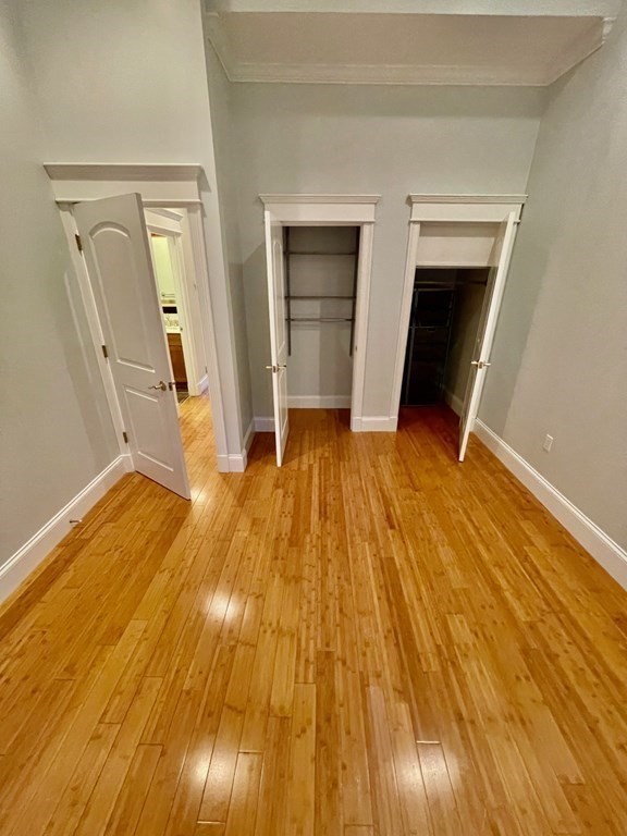 13 Worcester Square, Unit 2 Boston, MA 02118 - Photo 11 of 16 a view of an empty room with wooden floor and a fireplace