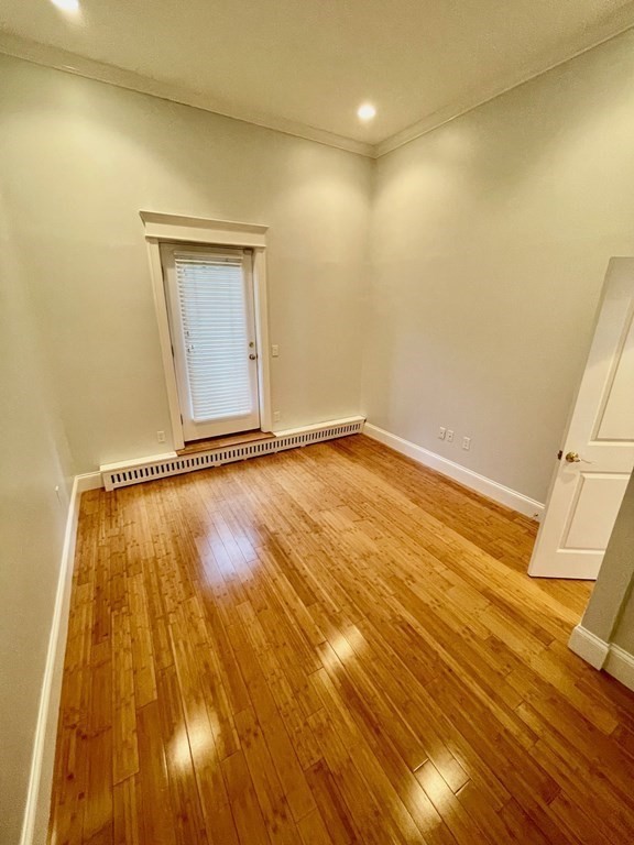13 Worcester Square, Unit 2 Boston, MA 02118 - Photo 13 of 16 a view of an empty room with wooden floor and a window
