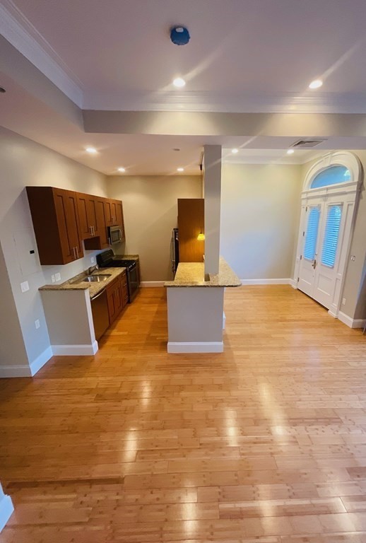 13 Worcester Square, Unit 2 Boston, MA 02118 - Photo 6 of 16 a view of kitchen and empty room with wooden floor