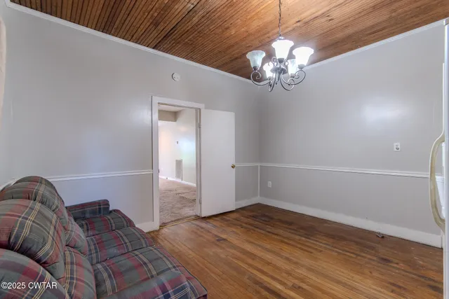 a living room with furniture a refrigerator and a chandelier