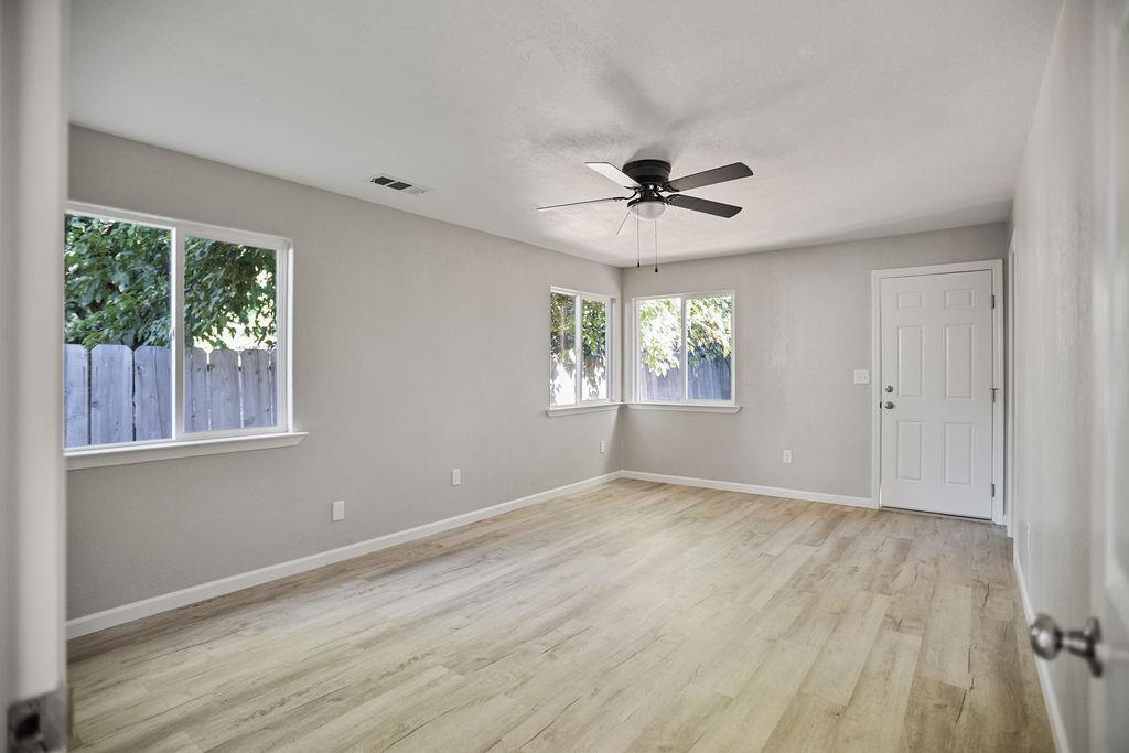 2525 R Street Merced, CA 95340 - Photo 9 of 12 a view of an empty room with a window and wooden floor