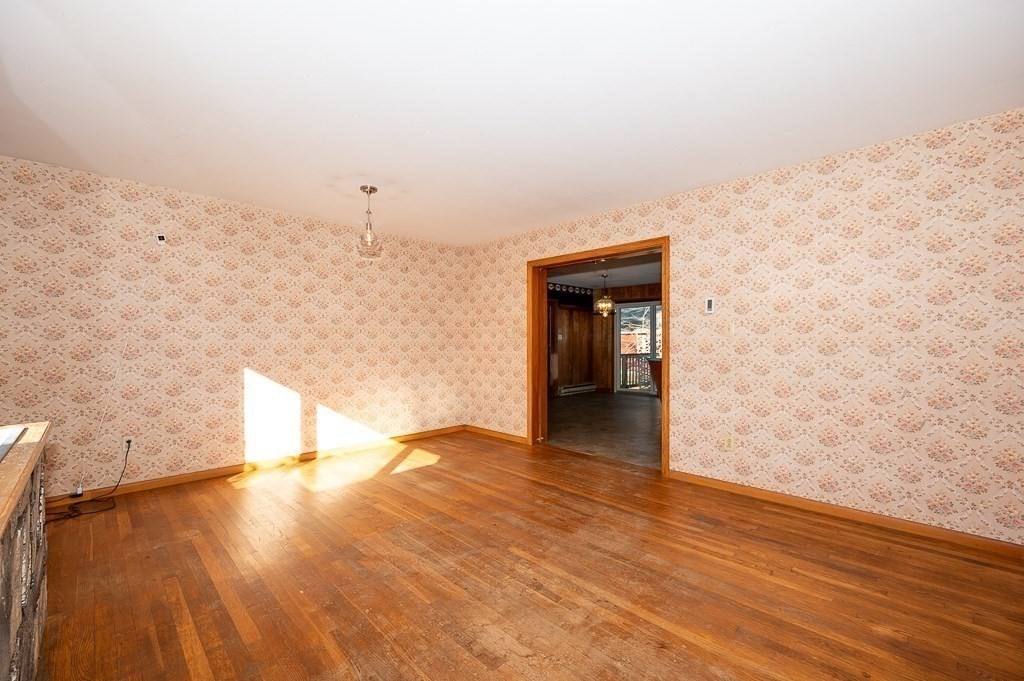31 Cemetery Street Mendon, MA 01756 - Photo 9 of 39 a view of a hallway with wooden floor and a fireplace