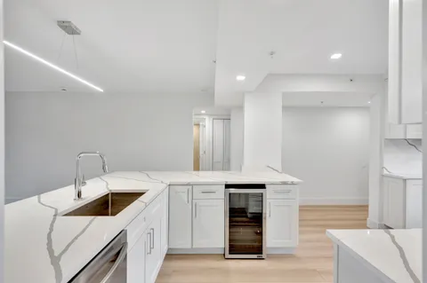 a large white kitchen with a table and chairs