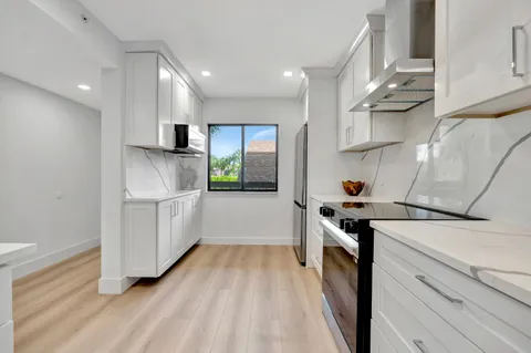 a kitchen with white cabinets and sink