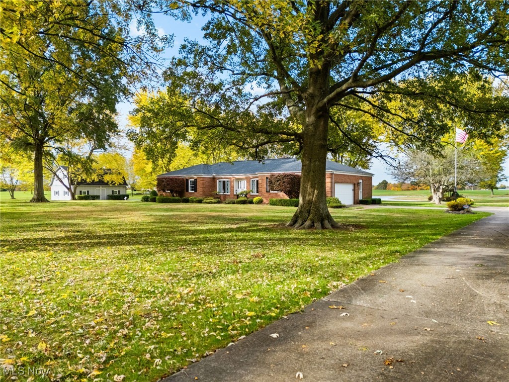 14265 Reeder Avenue Northeast Alliance, OH 44601 - Photo 2 of 39 View of front facade with a front lawn, brick siding, and an attached garage