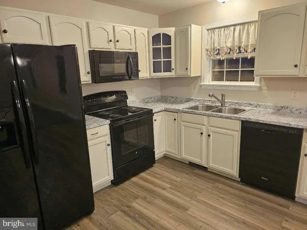 a kitchen with stainless steel appliances granite countertop a stove a sink dishwasher a refrigerator and a microwave oven