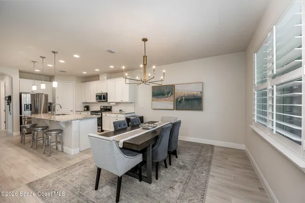 a dining room with a table chairs and a kitchen view