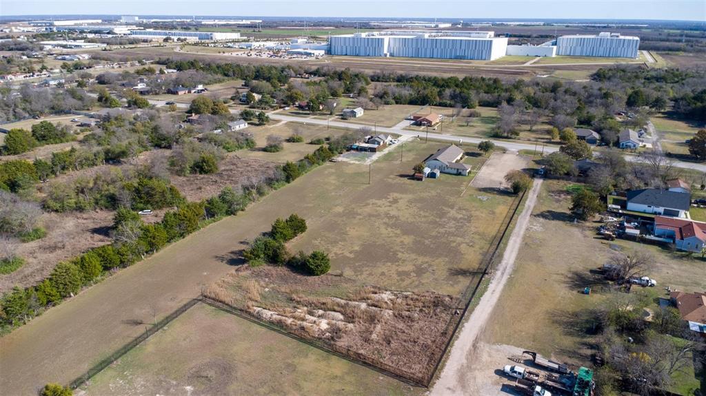 20 South Lancaster Hutchins Road Lancaster, TX 75146 - Photo 11 of 14 Expansive undeveloped land parcel featuring a perimeter fence, natural ground cover, scattered trees, and a gravel driveway