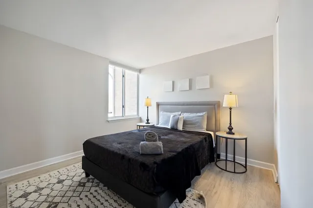 a bedroom with a bed lamp and a potted plant