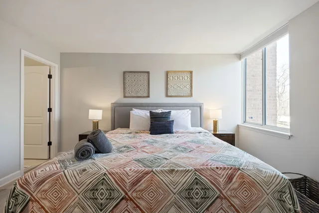 a bedroom with a bed and a lamp