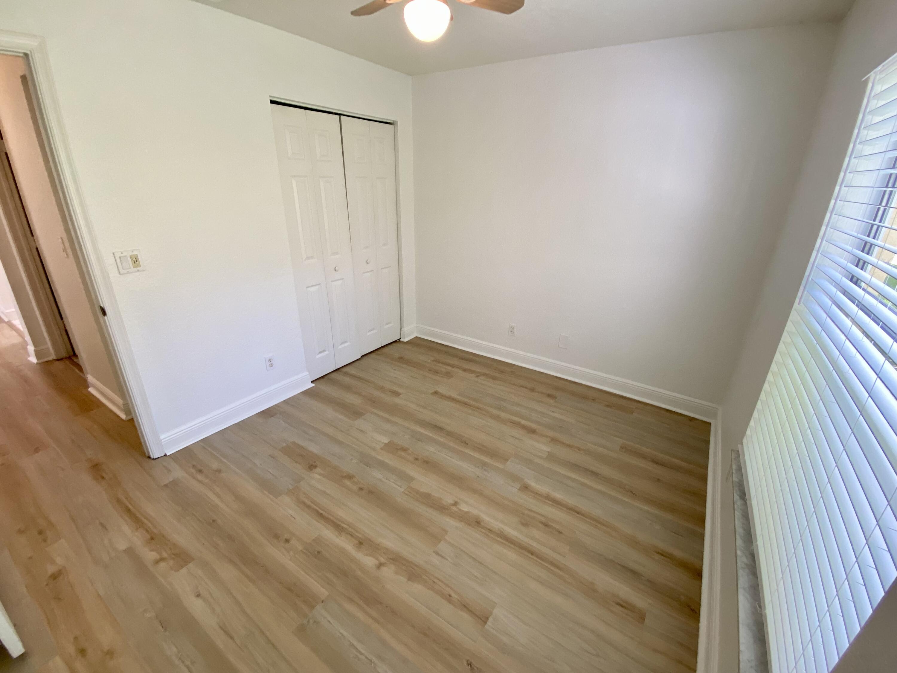 103 Pennock Landing Circle Jupiter, FL 33458 - Photo 7 of 18 an empty room with wooden floor and windows