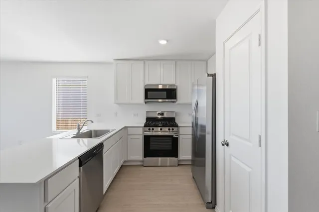 an empty room with kitchen view