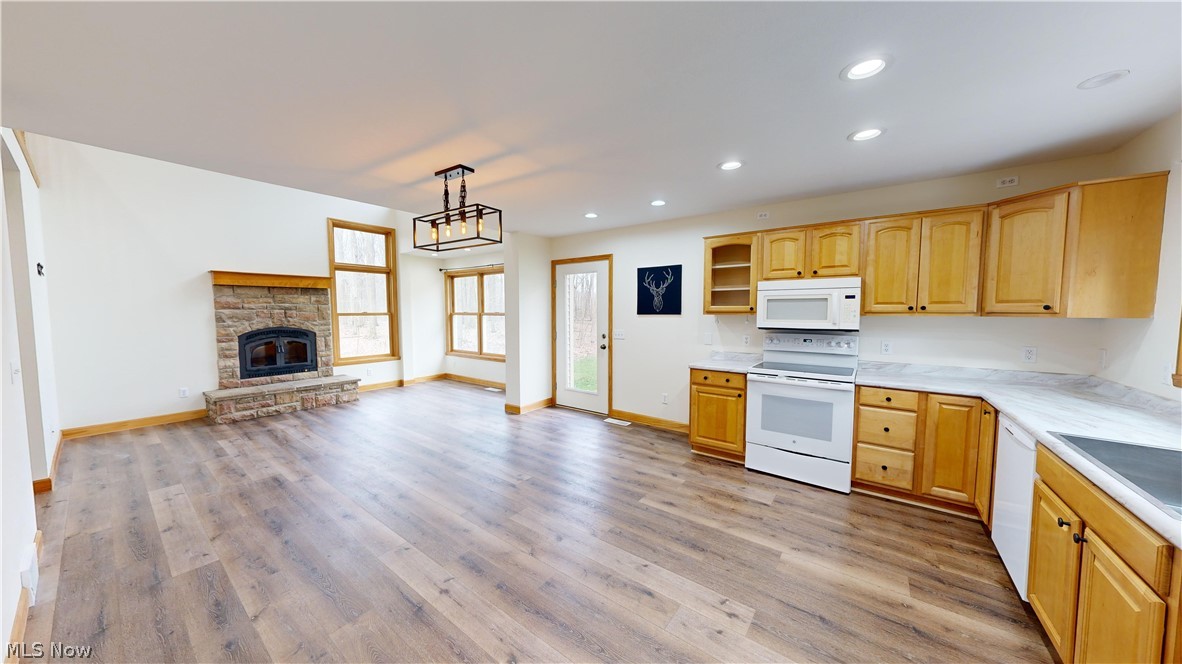 15548 Trask Road Thompson, OH 44086 - Photo 12 of 31 Kitchen with light brown cabinets, light hardwood / wood-style floors, a fireplace, white appliances, and hanging light fixtures