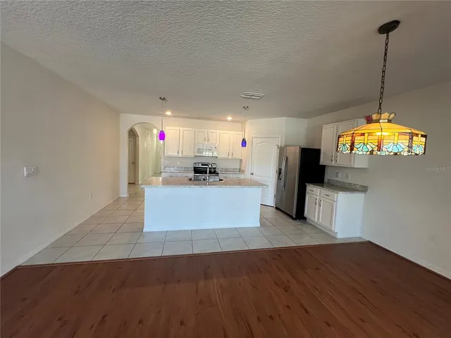 a kitchen with white cabinets and appliances