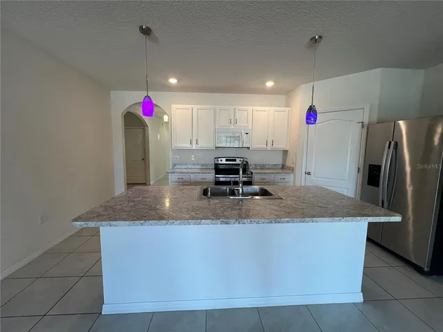 a view of a kitchen with refrigerator and cabinet