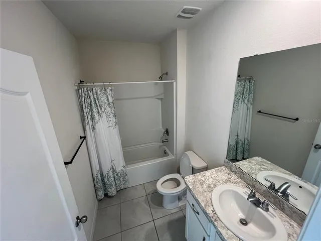 an empty room with wooden floor closet and windows