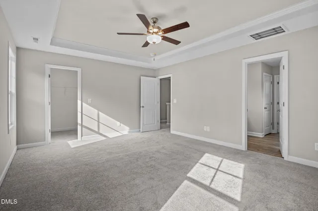 an empty room with closet and ceiling fan
