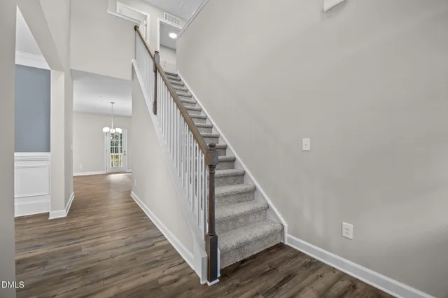 a view of a hallway with wooden floor and staircase