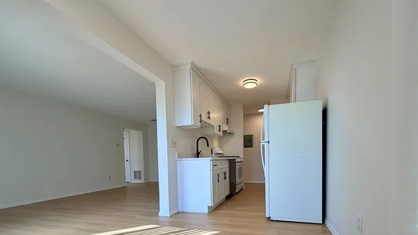a view of kitchen and closet with wooden floor