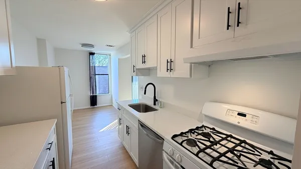 a kitchen with a sink a stove and cabinets