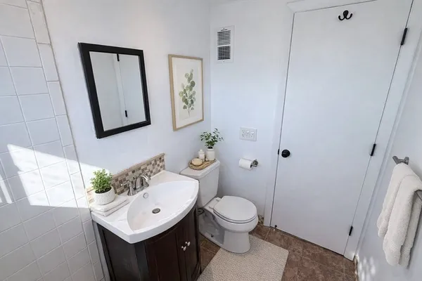 a bathroom with a sink vanity mirror and toilet