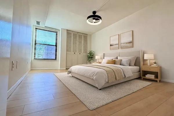 a bedroom with a large bed and a chandelier