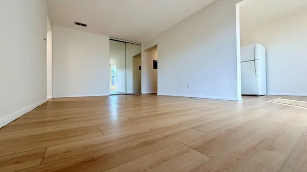 a view of an empty room with wooden floor