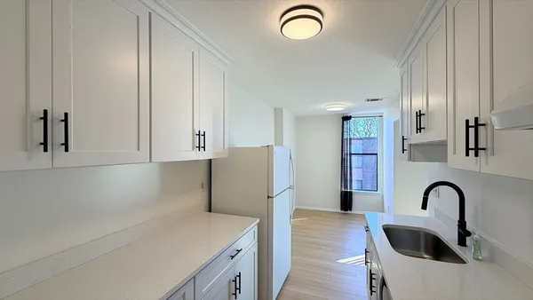 a kitchen with stainless steel appliances granite countertop a sink a refrigerator and cabinets