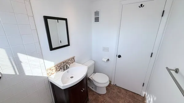 a bathroom with a toilet sink and mirror