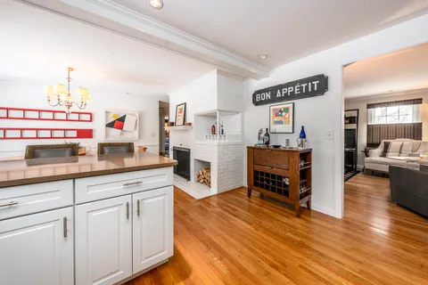 a kitchen with kitchen island a counter top space cabinets stainless steel appliances and wooden floor
