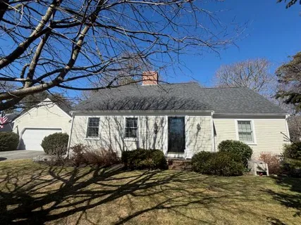 a view of a house with a yard and large tree