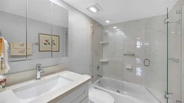 a bathroom with a bathtub shower sink vanity and toilet