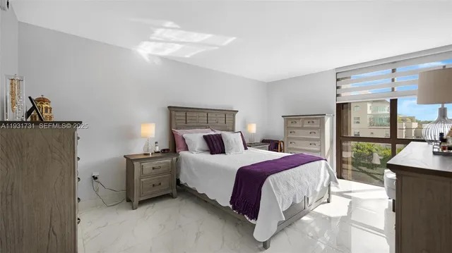 a spacious bedroom with a bed a table and large mirror