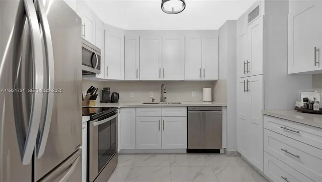 a kitchen with stainless steel appliances granite countertop a refrigerator sink and stove