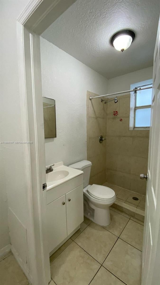1021 Northwest 3rd Street, Unit 206 Miami, FL 33128 - Photo 8 of 13 a bathroom with a toilet a sink a shower and mirror