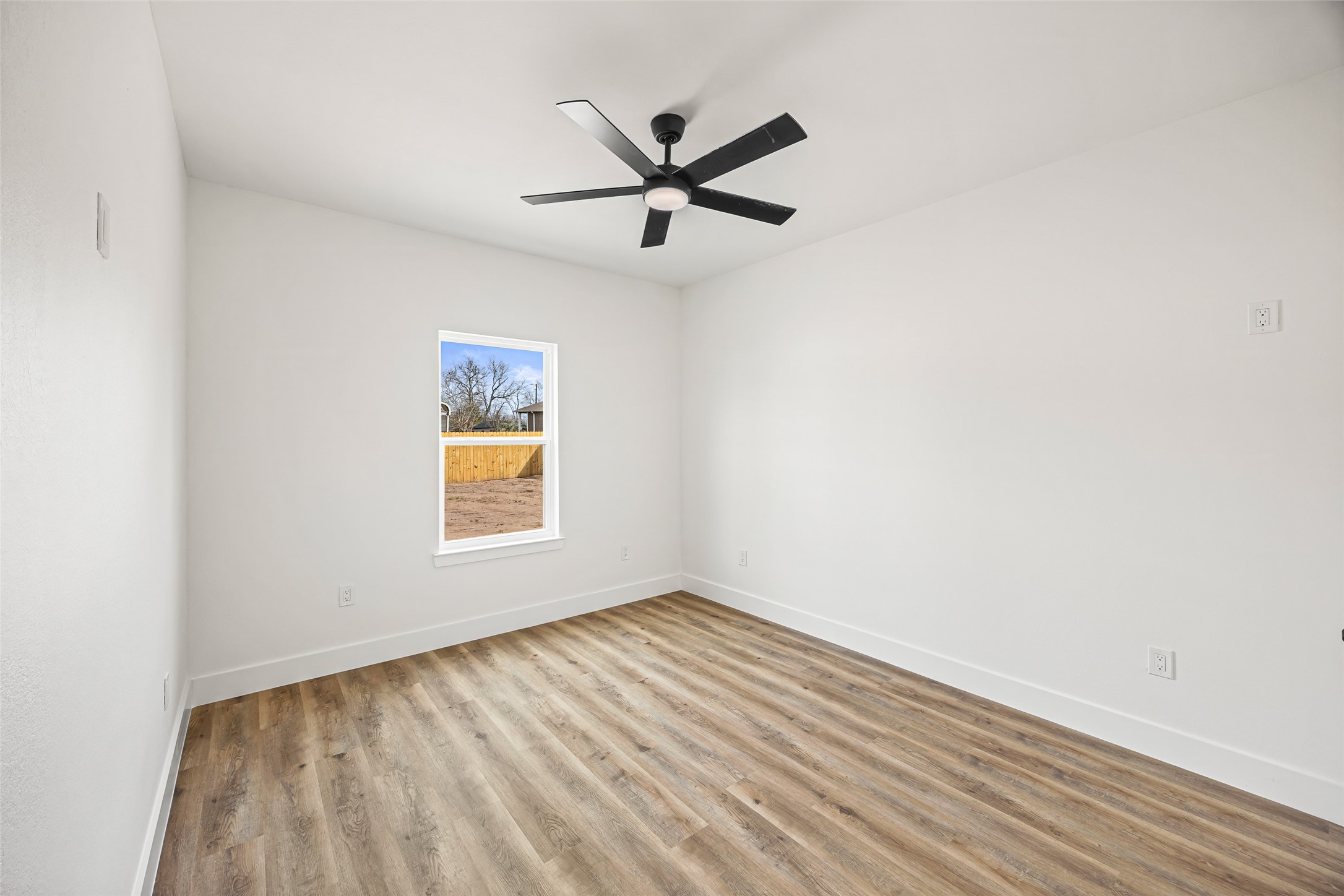 1807 Waco Street Dayton, TX 77535 - Photo 21 of 26 Comfortable bedroom with ceiling fan and backyard views.