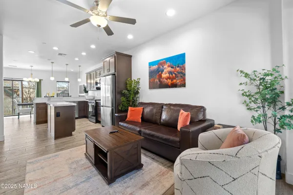 a living room with furniture kitchen view and a potted plant