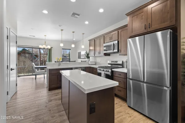 a kitchen with kitchen island a counter top space stainless steel appliances and cabinets