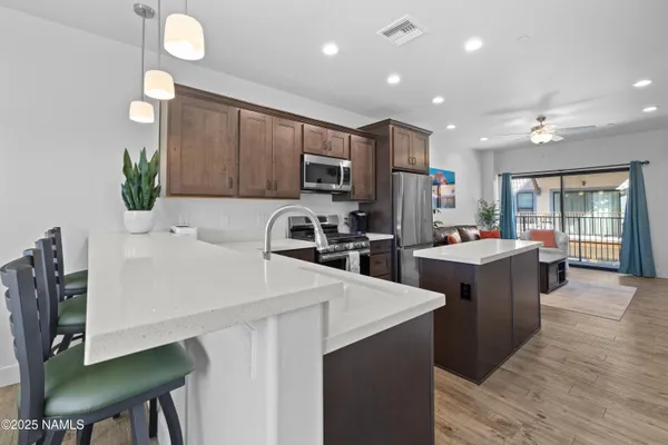 a kitchen with sink a refrigerator and chairs
