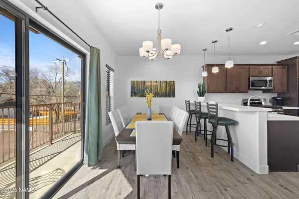 a view of a dining room with furniture a chandelier and wooden floor
