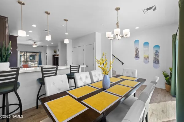 a room with lots of white furniture and wooden floor