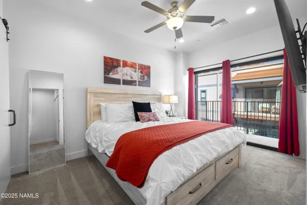a bedroom with a large bed and a chandelier