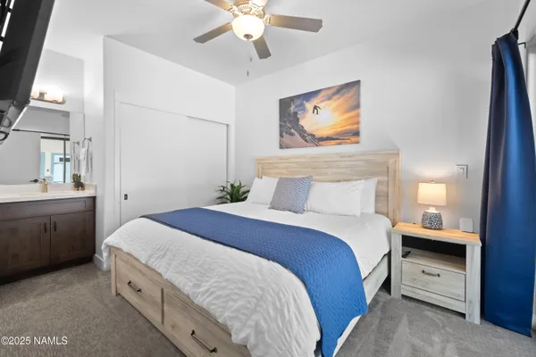 a spacious bedroom with a bed and a chandelier