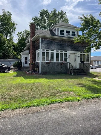 a view of a house with a yard and sitting area