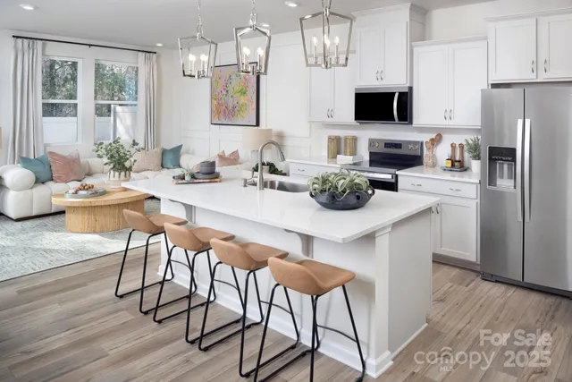 a kitchen with stainless steel appliances a dining table chairs microwave and sink