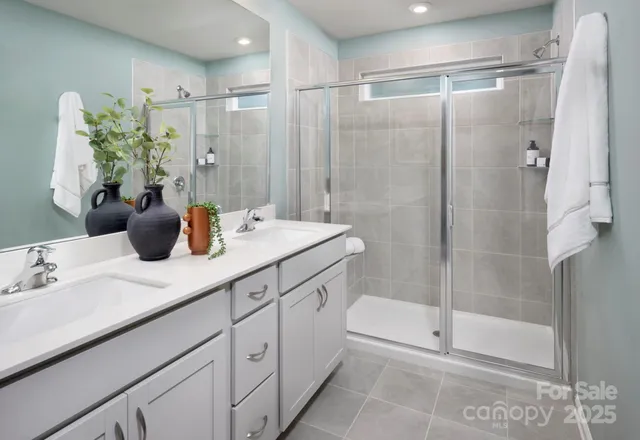 a bathroom with a double vanity sink and shower