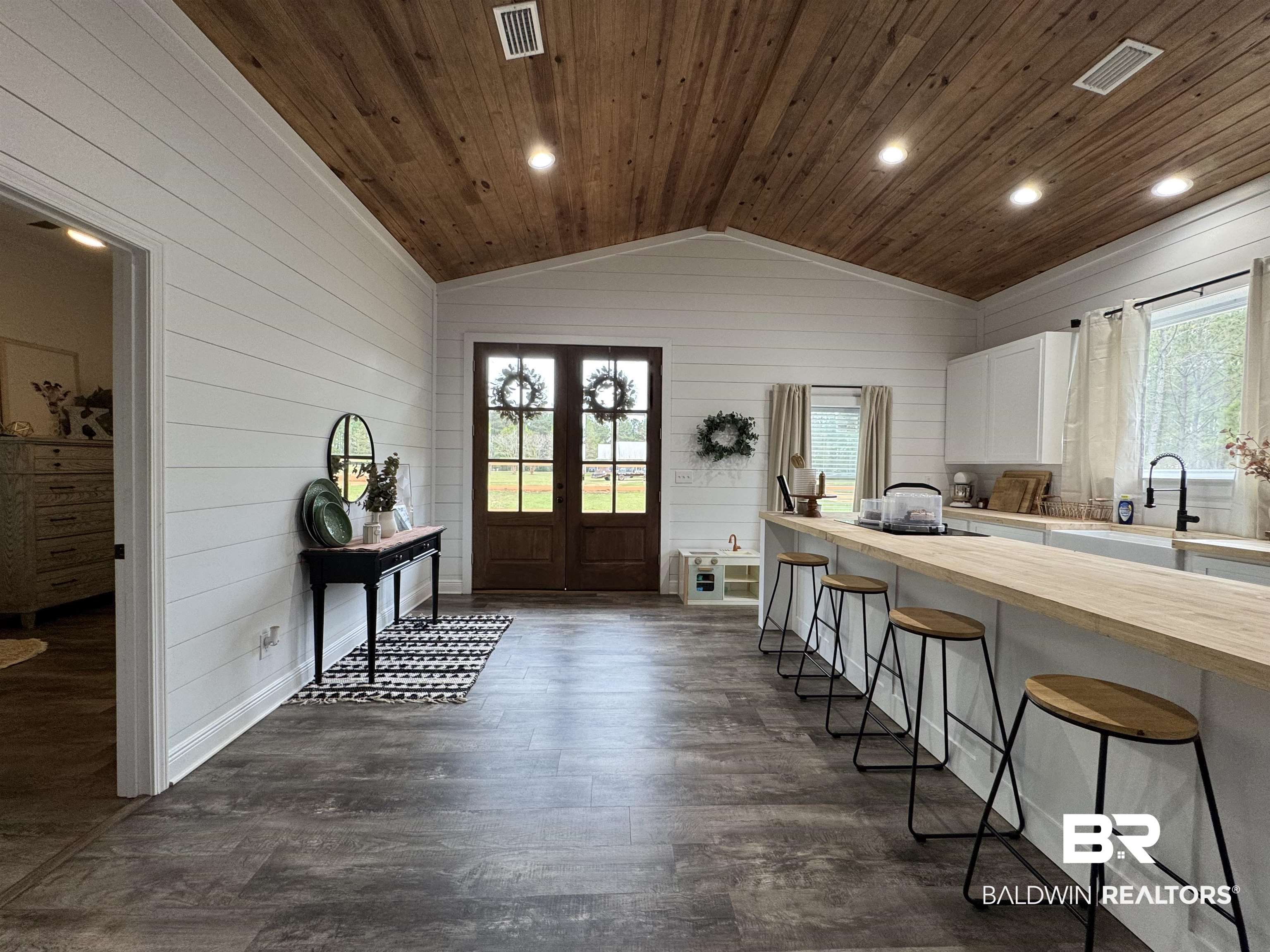 370 Dianne Road Frisco City, AL 36445 - Photo 16 of 41 Entryway featuring french doors, dark hardwood / wood-style flooring, lofted ceiling, wooden walls, and wooden ceiling opening into the kitchen