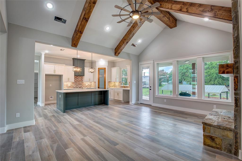 405 Door Key Ranch Road Trinidad, TX 75163 - Photo 6 of 28 Unfurnished living room featuring ceiling fan, light hardwood / wood-style flooring, a healthy amount of sunlight, and beam ceiling