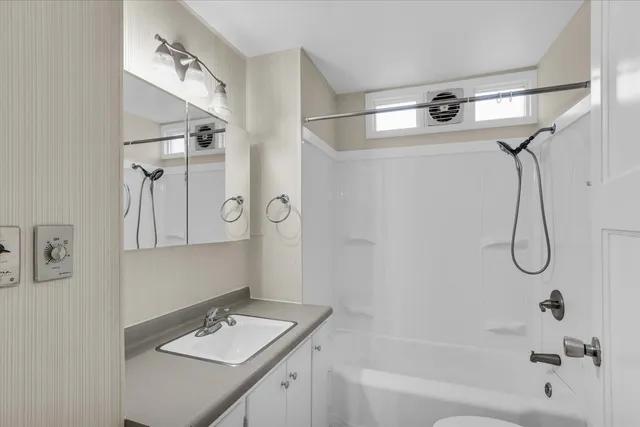 a bathroom with a tub sink vanity and mirror